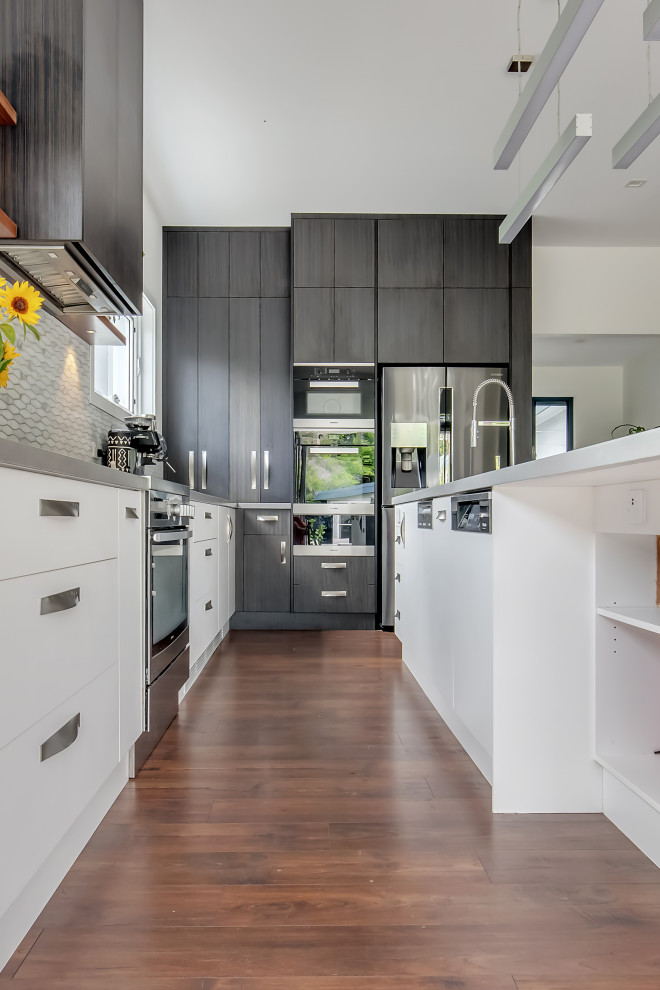 Inspiration for a large contemporary l-shaped kitchen pantry in Sydney with an undermount sink, flat-panel cabinets, dark wood cabinets, solid surface benchtops, multi-coloured splashback, marble splashback, stainless steel appliances, medium hardwood floors, with island, brown floor and grey benchtop.