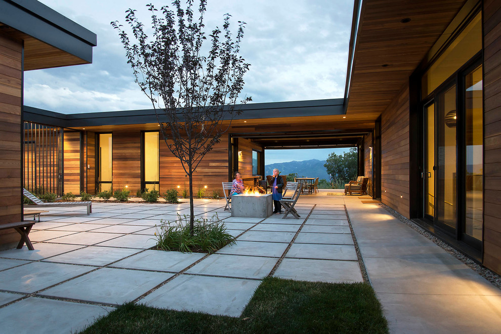 Photo of a large modern courtyard patio in Salt Lake City with a container garden, concrete pavers and a roof extension.