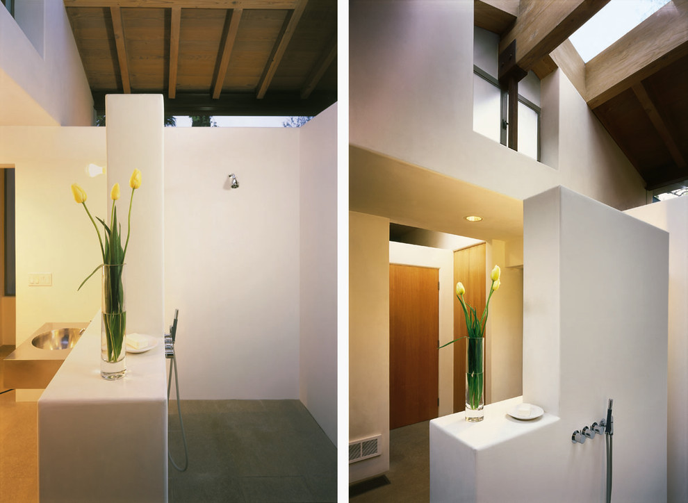 Inspiration for a transitional master limestone floor doorless shower remodel in Los Angeles with a wall-mount sink, furniture-like cabinets, stainless steel countertops and white walls