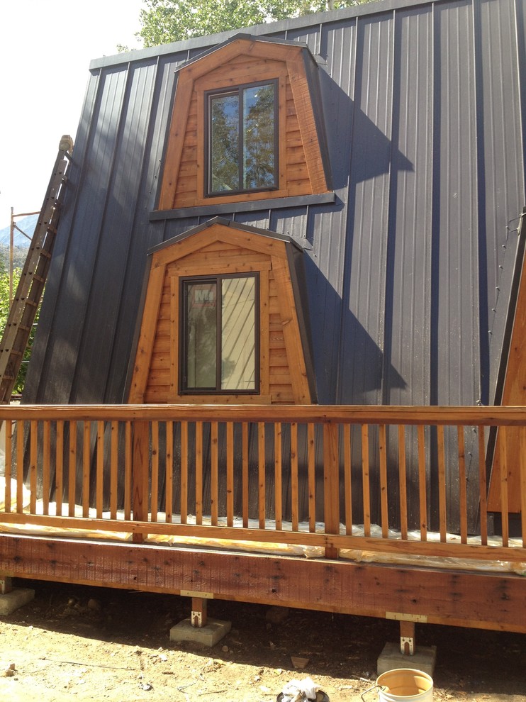 Example of a large mountain style brown two-story wood house exterior design with a metal roof