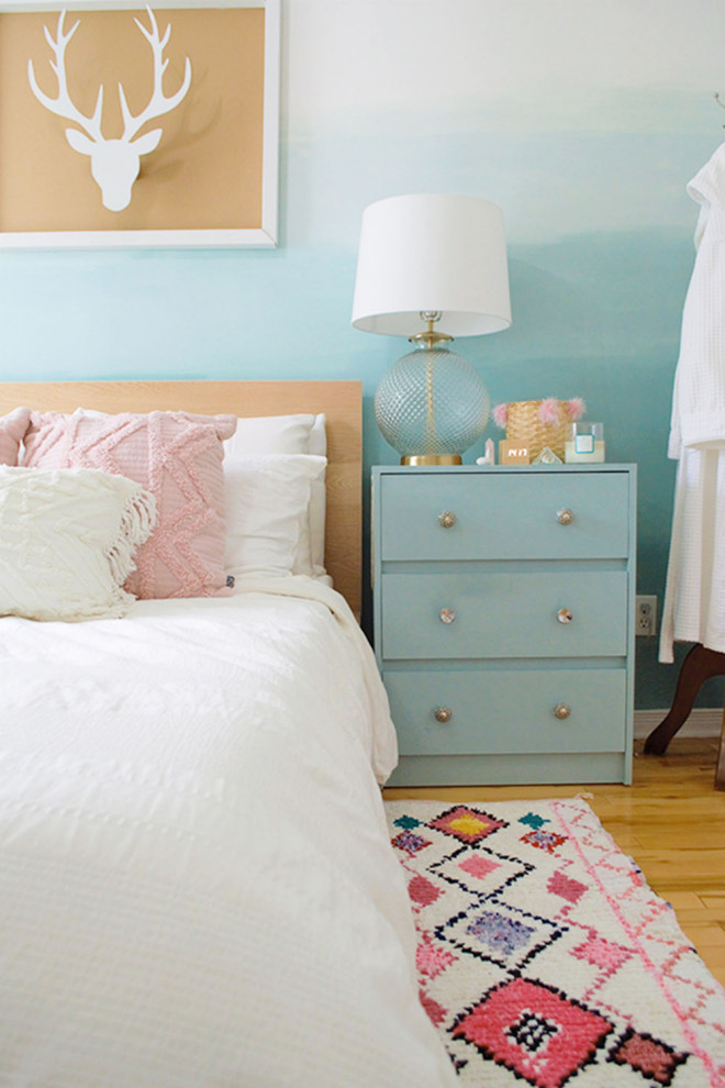 Foto de dormitorio principal costero de tamaño medio sin chimenea con paredes azules y suelo de madera clara