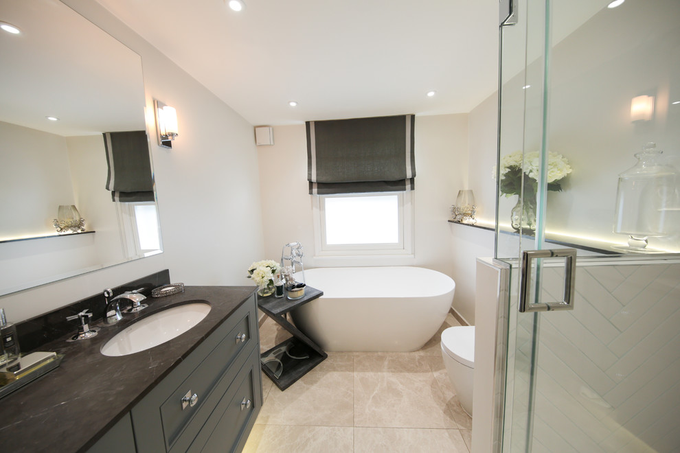 This is an example of a contemporary bathroom in London with a freestanding tub, white walls and a hinged shower door.