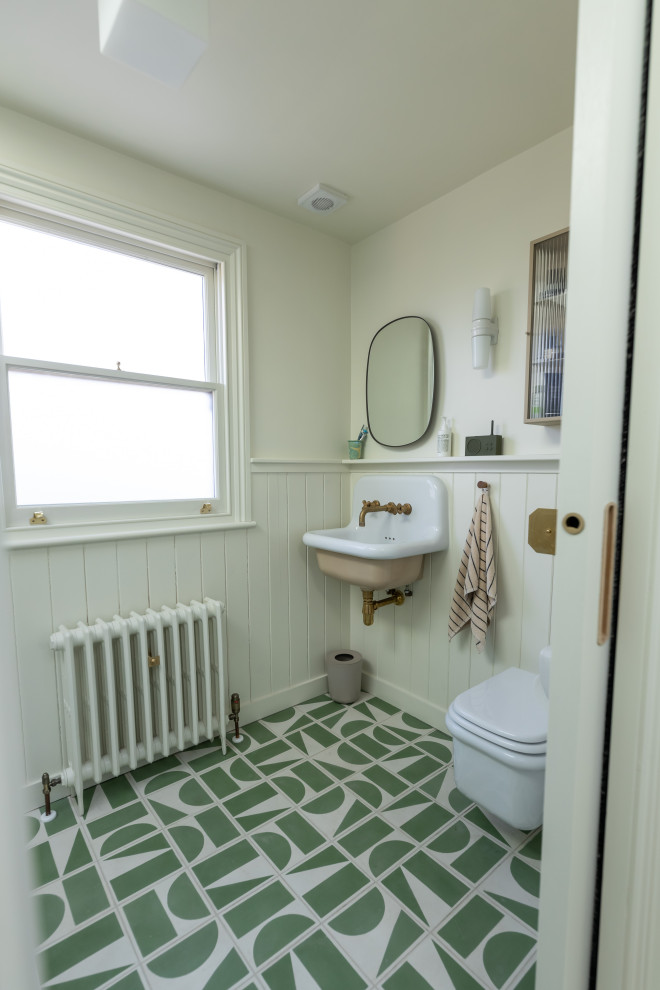Источник вдохновения для домашнего уюта: туалет в стиле неоклассика (современная классика) с белыми стенами, подвесной раковиной, зеленым полом и панелями на стенах