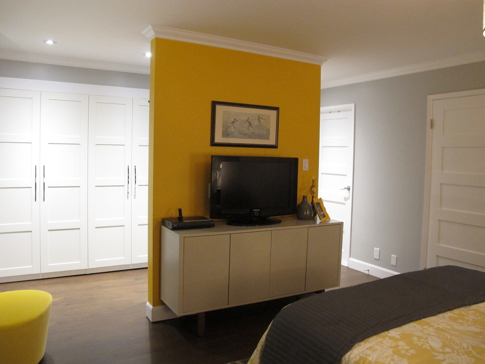 Large contemporary master bedroom in Montreal with yellow walls, dark hardwood floors and brown floor.