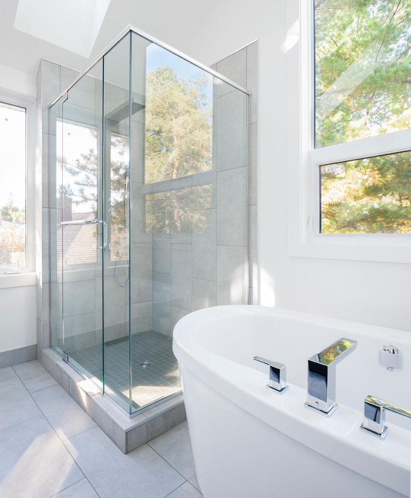 Inspiration for a large transitional master bathroom in Ottawa with flat-panel cabinets, black cabinets, a freestanding tub, a corner shower, a one-piece toilet, gray tile, porcelain tile, white walls, ceramic floors, an integrated sink and concrete benchtops.