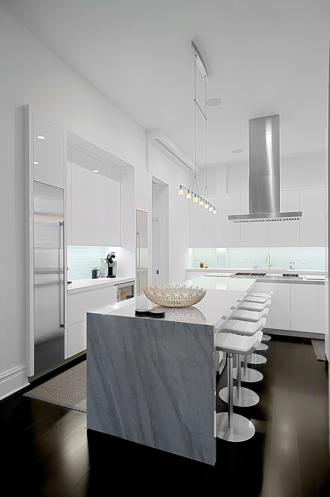 Mid-sized modern u-shaped eat-in kitchen in Chicago with an undermount sink, flat-panel cabinets, white cabinets, marble benchtops, white splashback, mosaic tile splashback, stainless steel appliances, dark hardwood floors, with island, brown floor and grey benchtop.