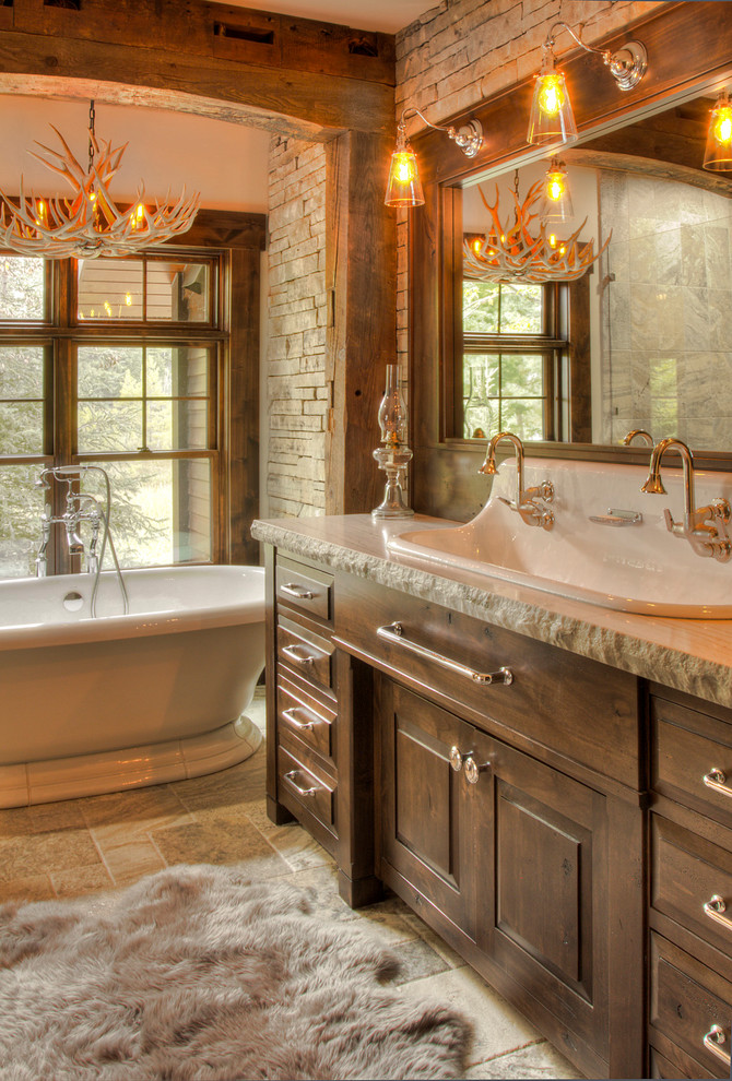 Photo of a large country master bathroom in Minneapolis with raised-panel cabinets, dark wood cabinets, a freestanding tub, white tile, stone tile, ceramic floors, a trough sink, granite benchtops, grey floor and white benchtops.