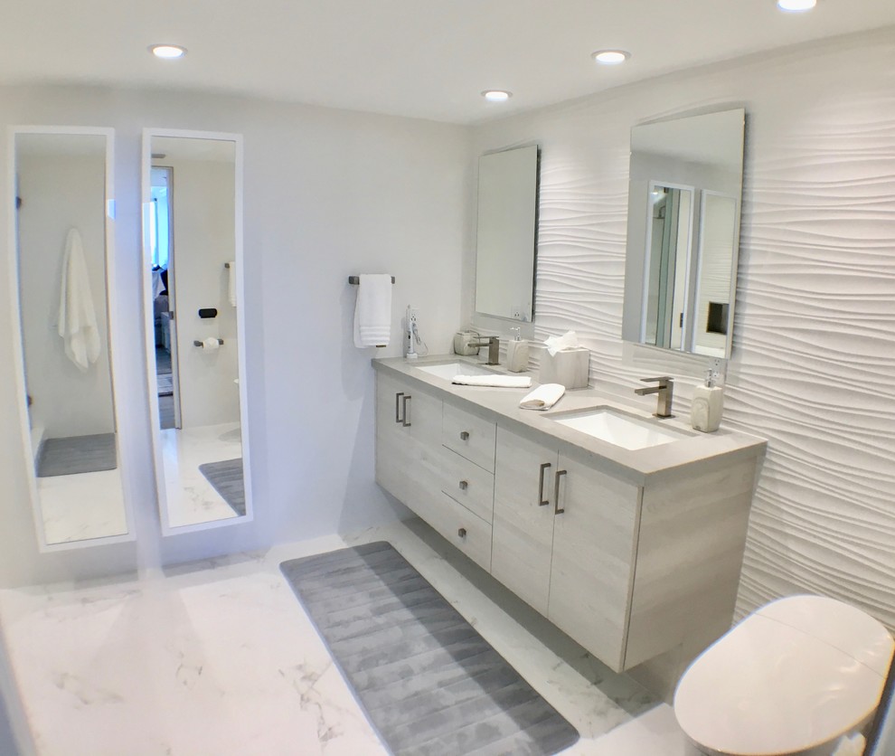 Inspiration for a small modern master bathroom in Miami with flat-panel cabinets, grey cabinets, a freestanding tub, a corner shower, a one-piece toilet, gray tile, porcelain tile, grey walls, porcelain floors, an undermount sink, engineered quartz benchtops, grey floor and a hinged shower door.