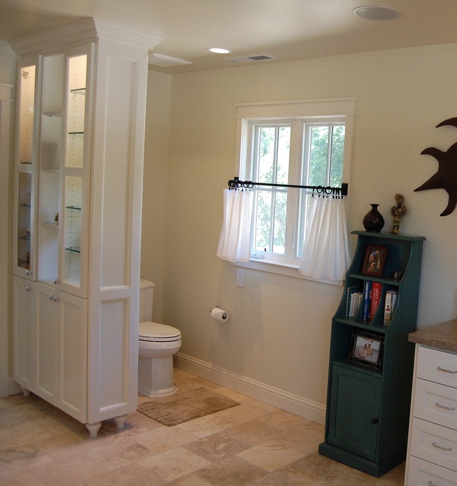 Design ideas for a large traditional master bathroom in Orange County with an undermount sink, recessed-panel cabinets, white cabinets, limestone benchtops, a curbless shower, a two-piece toilet, beige tile, stone tile and white walls.
