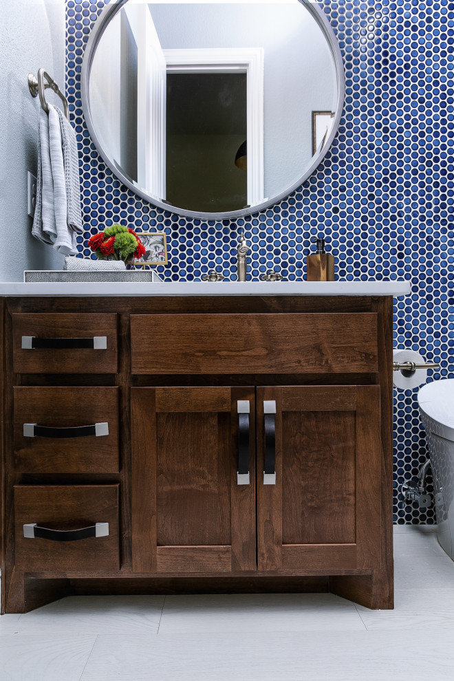 Photo of a mid-sized transitional 3/4 bathroom in Chicago with raised-panel cabinets, brown cabinets, quartzite benchtops, white benchtops, a double shower, a one-piece toilet, blue tile, cement tile, blue walls, light hardwood floors, a drop-in sink, white floor and a shower curtain.