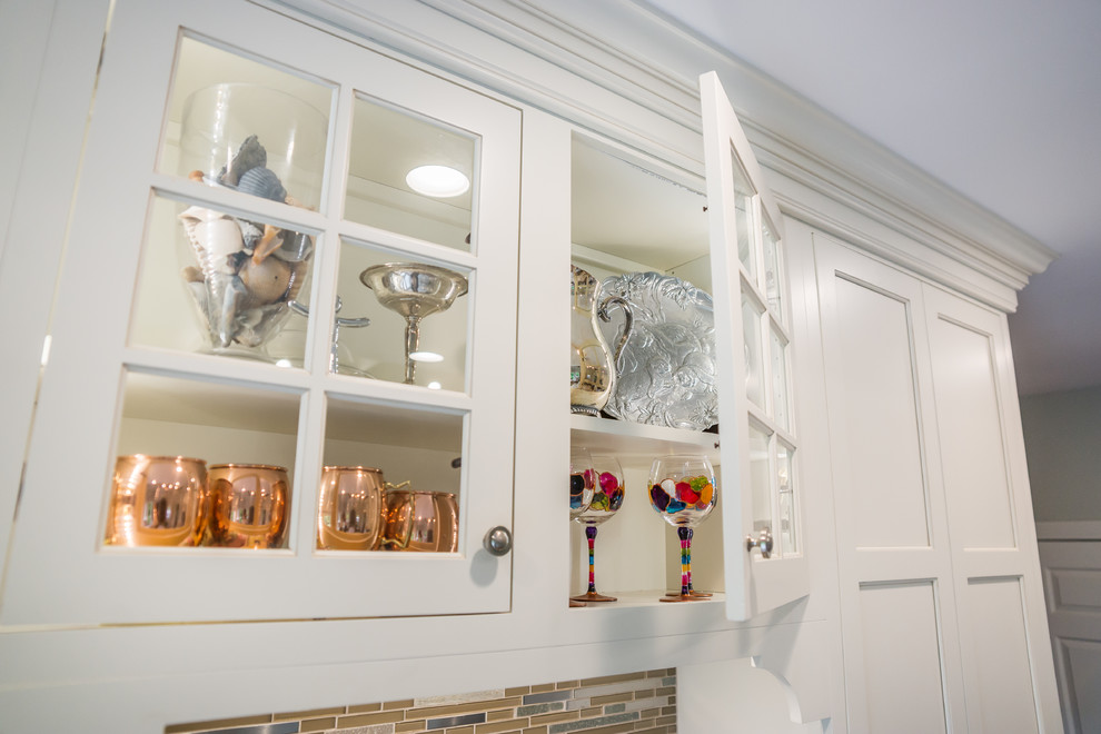 Huge transitional l-shaped medium tone wood floor eat-in kitchen photo in Birmingham with an undermount sink, recessed-panel cabinets, white cabinets, granite countertops, multicolored backsplash, glass tile backsplash, stainless steel appliances and an island