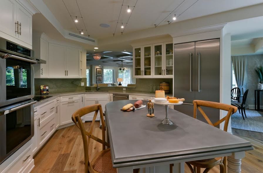 Inspiration for a large transitional u-shaped medium tone wood floor enclosed kitchen remodel in Miami with an undermount sink, shaker cabinets, white cabinets, quartz countertops, green backsplash, stone slab backsplash, stainless steel appliances and an island