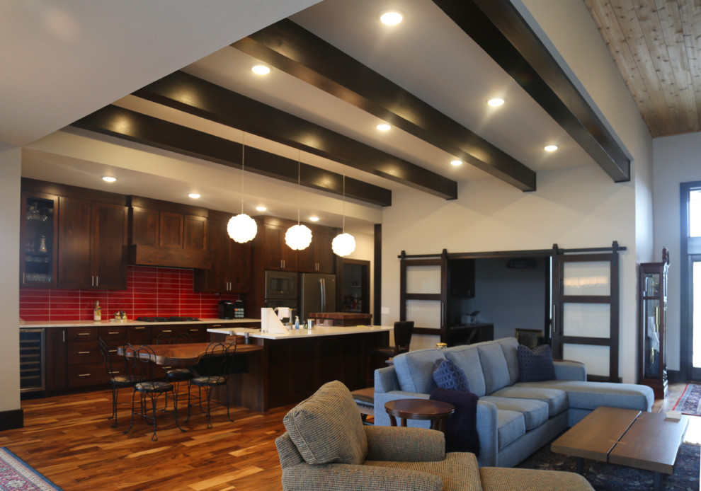Example of a mid-sized transitional galley medium tone wood floor eat-in kitchen design with a double-bowl sink, recessed-panel cabinets, dark wood cabinets, granite countertops, red backsplash, porcelain backsplash, stainless steel appliances and an island