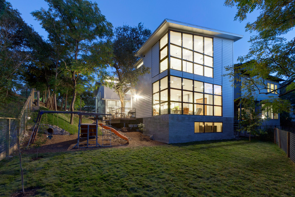 Photo of a large transitional two-storey white exterior in Austin with wood siding.