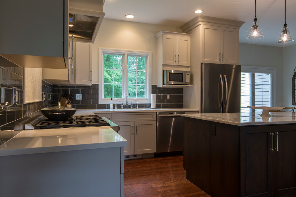 Eat-in kitchen - mid-sized transitional l-shaped medium tone wood floor eat-in kitchen idea in Bridgeport with an undermount sink, recessed-panel cabinets, gray cabinets, granite countertops, black backsplash, ceramic backsplash, stainless steel appliances and an island