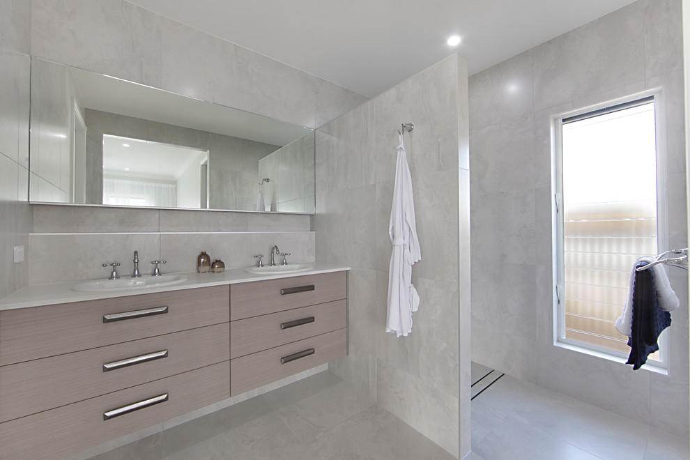 Mid-sized transitional master bathroom in Townsville with flat-panel cabinets, light wood cabinets, an alcove shower, gray tile, porcelain tile, porcelain floors, a drop-in sink, engineered quartz benchtops, grey floor and an open shower.