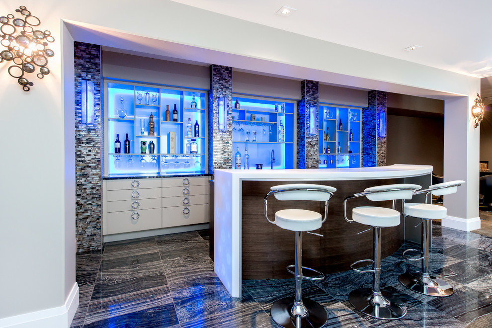 Photo of a large contemporary galley seated home bar in Calgary with flat-panel cabinets, white cabinets, porcelain floors, black floor and onyx benchtops.