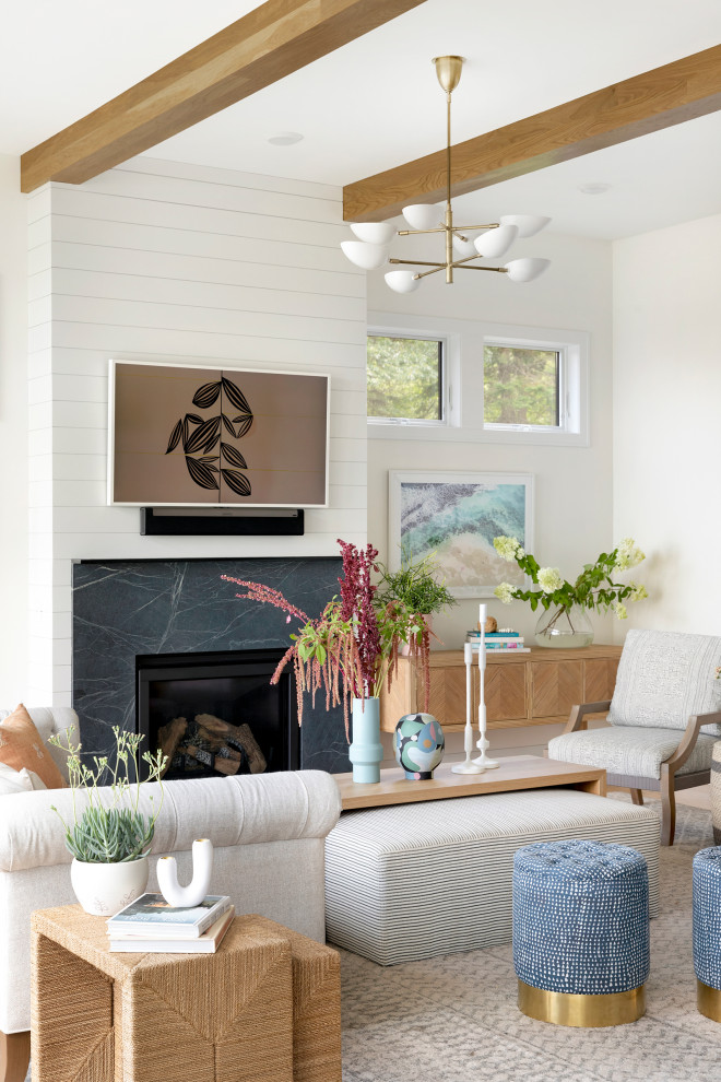 Large beach style living room in Minneapolis with white walls, carpet, beige floor and exposed beam.