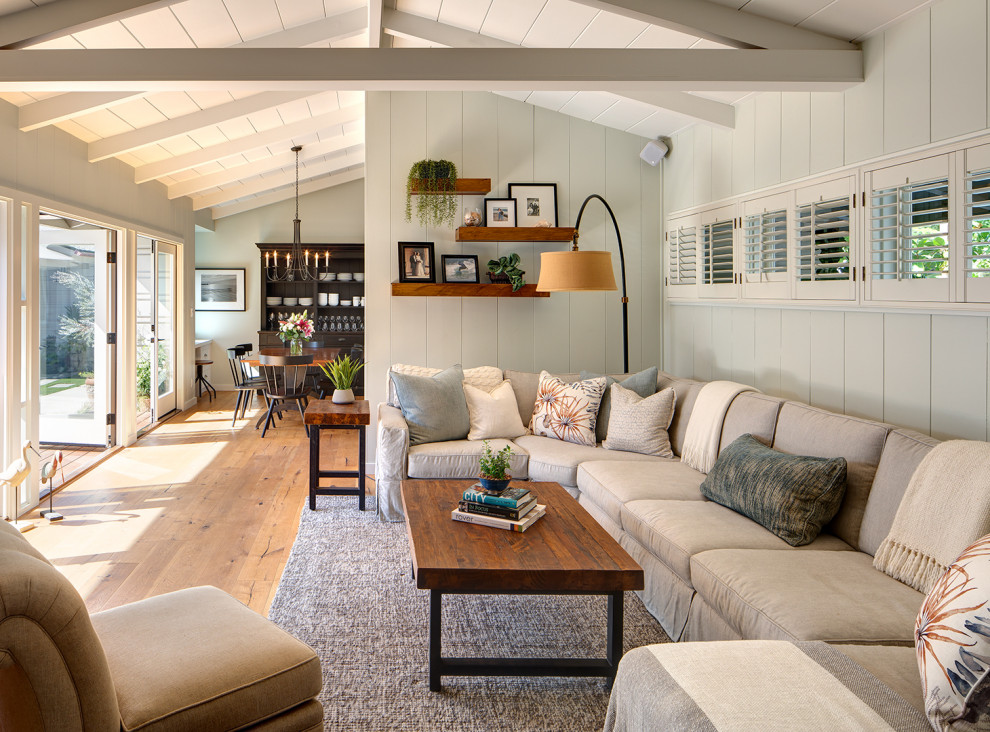 Example of a mid-sized beach style open concept medium tone wood floor, brown floor, shiplap ceiling and shiplap wall family room design in San Diego with white walls and a wall-mounted tv