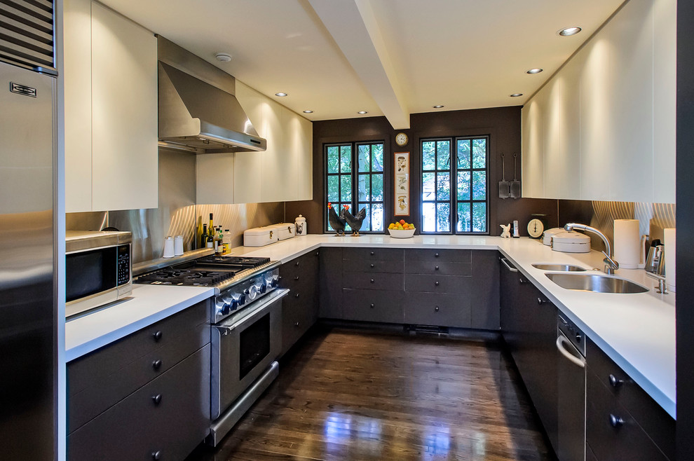 Traditional u-shaped separate kitchen in San Francisco with flat-panel cabinets, black cabinets, metallic splashback and metal splashback.