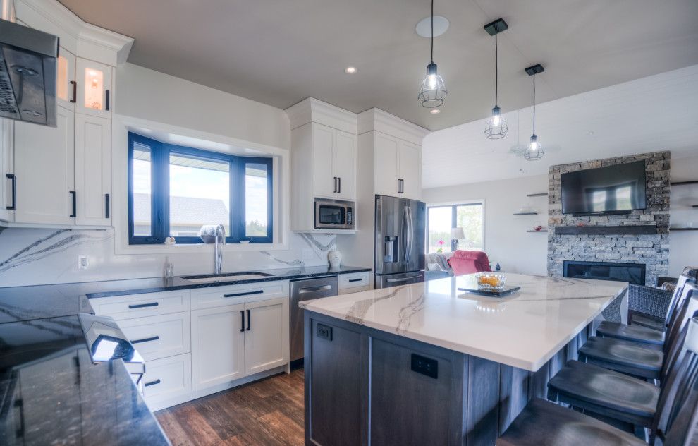 Example of a transitional eat-in kitchen design with shaker cabinets, white cabinets, stainless steel appliances and an island