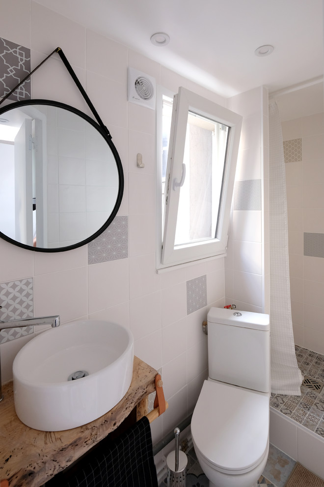 Aménagement d'une petite salle d'eau scandinave avec WC à poser, un carrelage blanc, des carreaux de céramique, un mur blanc, un sol en carrelage de céramique, une vasque, un plan de toilette en bois et une cabine de douche avec un rideau.