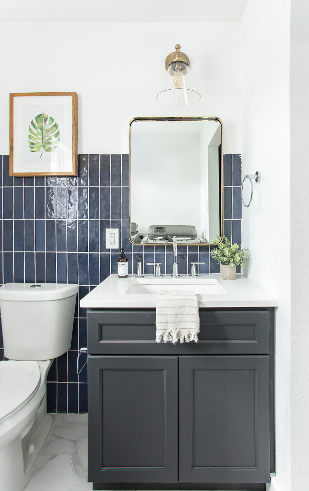 Photo of a mid-sized transitional powder room in Dallas with shaker cabinets, blue cabinets, white tile, ceramic tile, engineered quartz benchtops and white benchtops.