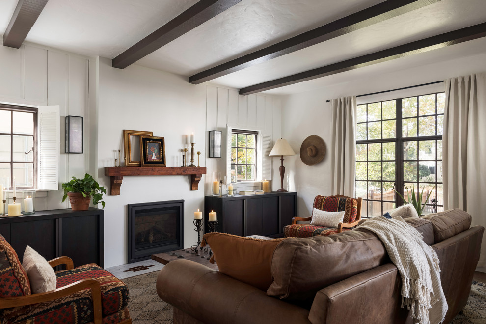 Inspiration for a mid-sized enclosed living room in Sacramento with white walls, medium hardwood floors, a standard fireplace, a plaster fireplace surround, exposed beam and panelled walls.