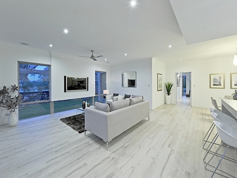 Design ideas for a mid-sized modern open concept family room in Perth with white walls, light hardwood floors and a wall-mounted tv.