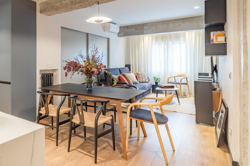 Small scandinavian kitchen/dining room in Madrid with beige walls, medium hardwood flooring and brown floors.