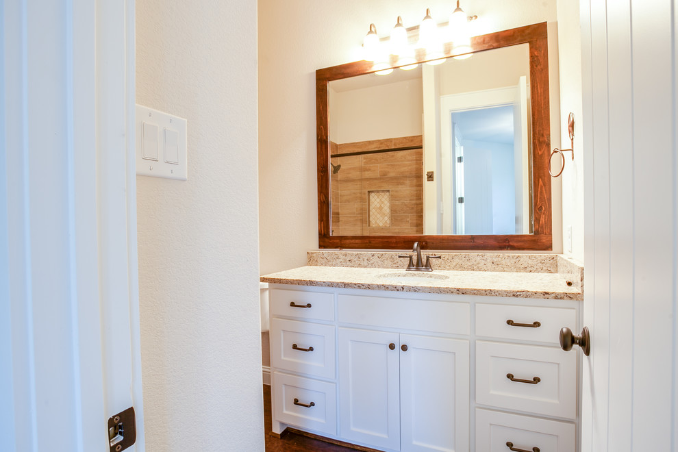Mid-sized country kids bathroom in Dallas with shaker cabinets, white cabinets, a shower/bathtub combo, beige tile, ceramic tile, beige walls, medium hardwood floors, an undermount sink, granite benchtops, brown floor and a shower curtain.