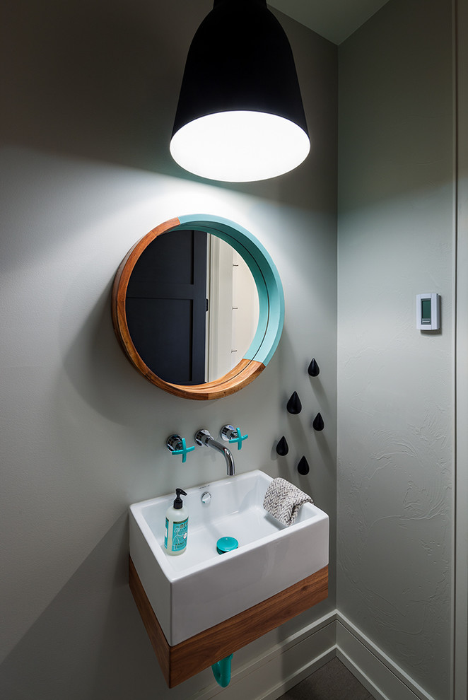Small trendy powder room photo with a wall-mount sink, gray walls, flat-panel cabinets and medium tone wood cabinets