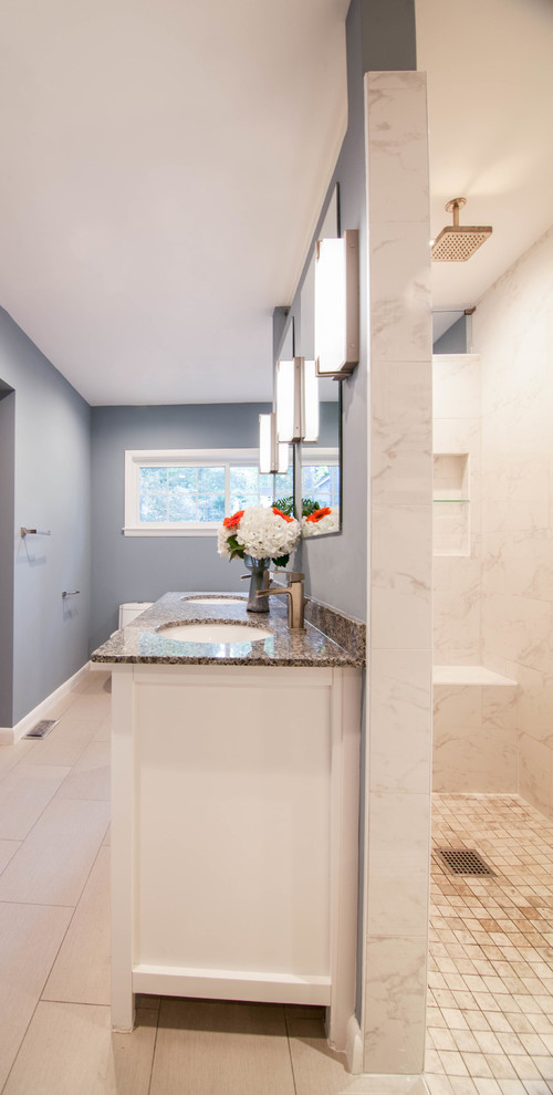 Example of a large transitional master white tile and ceramic tile ceramic tile and beige floor drop-in bathtub design in Atlanta with shaker cabinets, white cabinets, a one-piece toilet, blue walls, an undermount sink and granite countertops