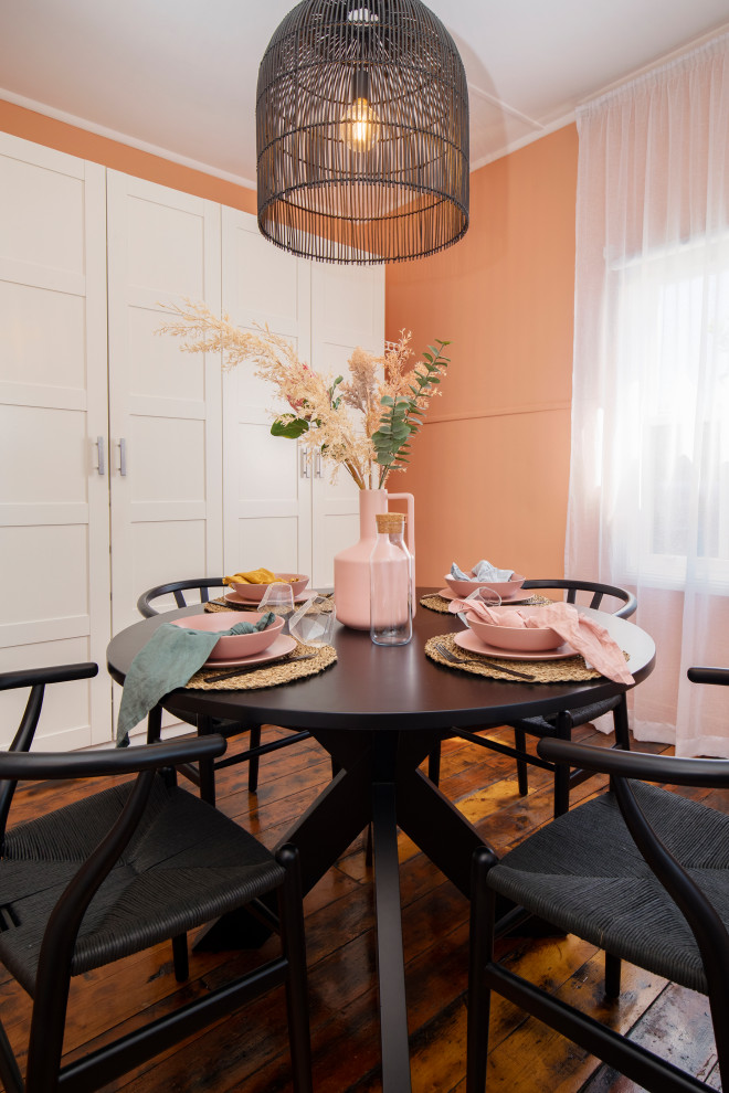 Esempio di una sala da pranzo mediterranea chiusa e di medie dimensioni con pareti arancioni, parquet scuro e pavimento marrone