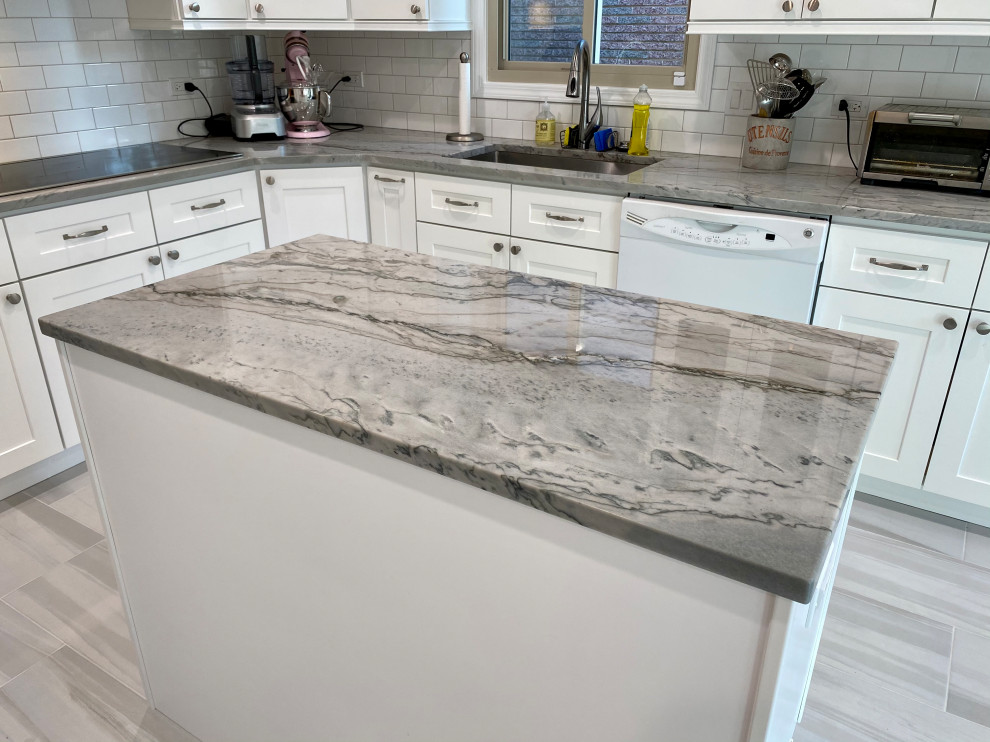 Inspiration for a mid-sized contemporary galley separate kitchen in Chicago with an undermount sink, shaker cabinets, white cabinets, quartzite benchtops, white splashback, subway tile splashback, stainless steel appliances, porcelain floors, with island, grey floor and grey benchtop.