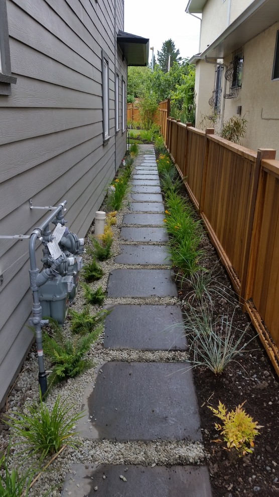 Photo of a small rustic drought-tolerant and partial sun side yard concrete paver garden path.