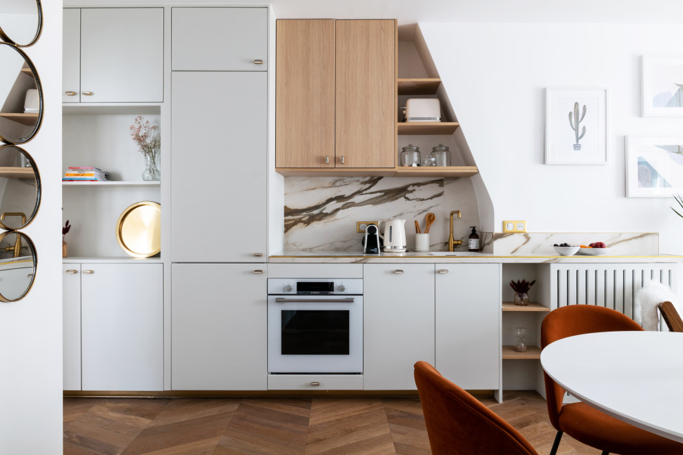 Foto di una cucina minimal di medie dimensioni con lavello sottopiano, ante grigie, top piastrellato, elettrodomestici bianchi e pavimento in legno massello medio