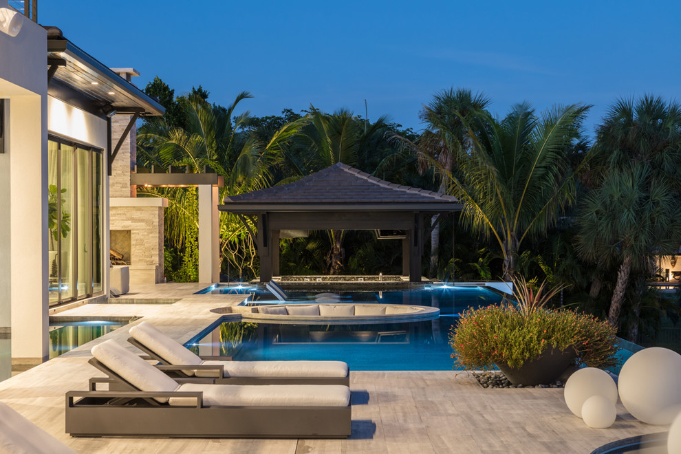 Design ideas for a beach style backyard custom-shaped pool in Tampa.