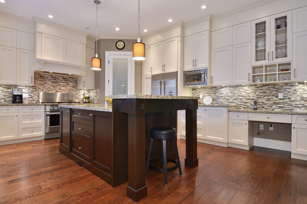 Photo of a mid-sized traditional u-shaped open plan kitchen in Vancouver with white cabinets, granite benchtops, multi-coloured splashback, glass sheet splashback, stainless steel appliances, dark hardwood floors, with island, an undermount sink and recessed-panel cabinets.