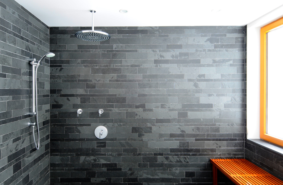 This is an example of a contemporary master bathroom in Toronto with flat-panel cabinets, a drop-in tub, an open shower, a one-piece toilet, black tile, slate, black walls, slate floors, black floor and an open shower.