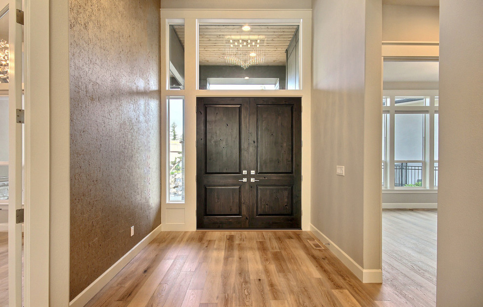 Пример оригинального дизайна: огромная входная дверь в стиле модернизм с бежевыми стенами, светлым паркетным полом, двустворчатой входной дверью, входной дверью из темного дерева, коричневым полом и обоями на стенах