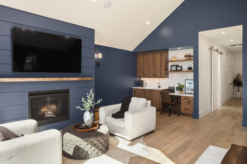 シアトルにある巨大なトランジショナルスタイルのおしゃれな主寝室 (青い壁、無垢フローリング、標準型暖炉、塗装板張りの暖炉まわり、三角天井、塗装板張りの壁)