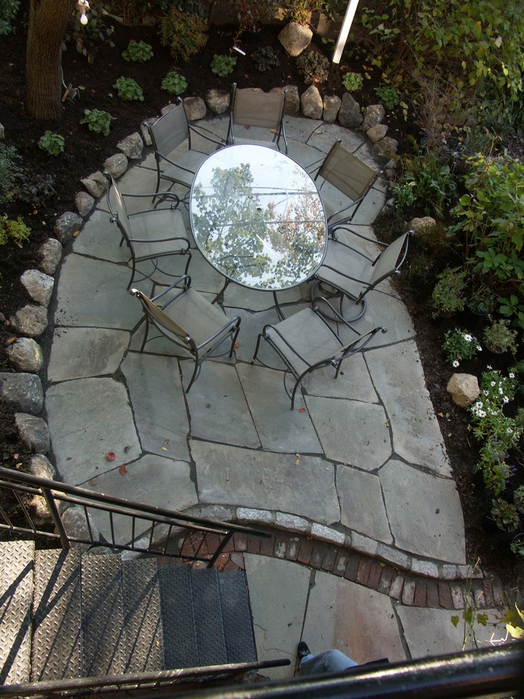 This is an example of a mid-sized traditional courtyard patio in New York with a container garden and natural stone pavers.