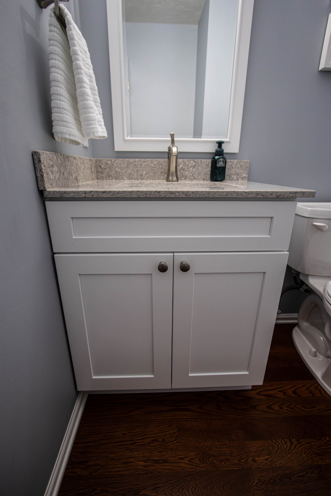 Exemple d'un petit WC et toilettes chic avec un placard à porte plane, des portes de placard blanches, un mur gris, un lavabo encastré, un plan de toilette en quartz modifié, un plan de toilette gris et meuble-lavabo encastré.