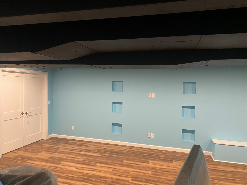 Ejemplo de sótano en el subsuelo contemporáneo de tamaño medio con paredes azules, suelo vinílico y suelo multicolor