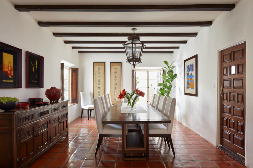 This is an example of a mediterranean separate dining room in Los Angeles with white walls, terra-cotta floors and red floor.