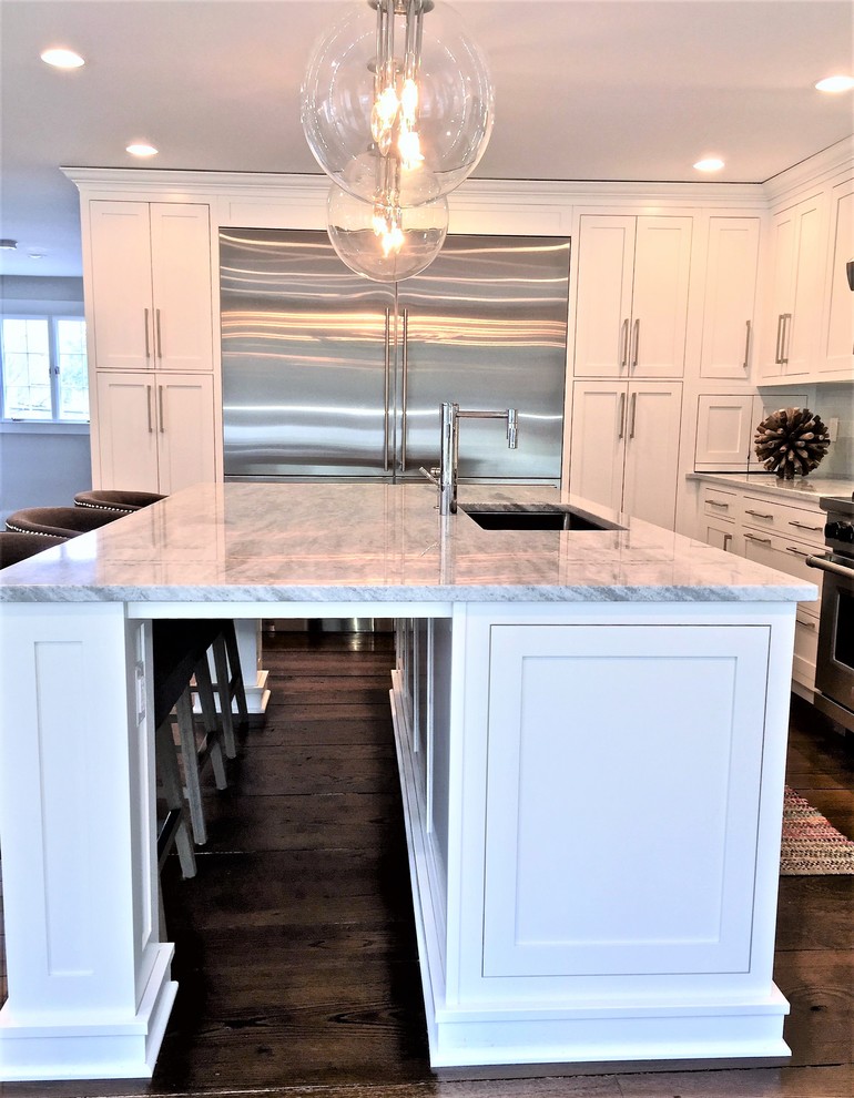 Transitional l-shaped eat-in kitchen photo in New York with shaker cabinets, white cabinets, quartz countertops, stainless steel appliances and an island