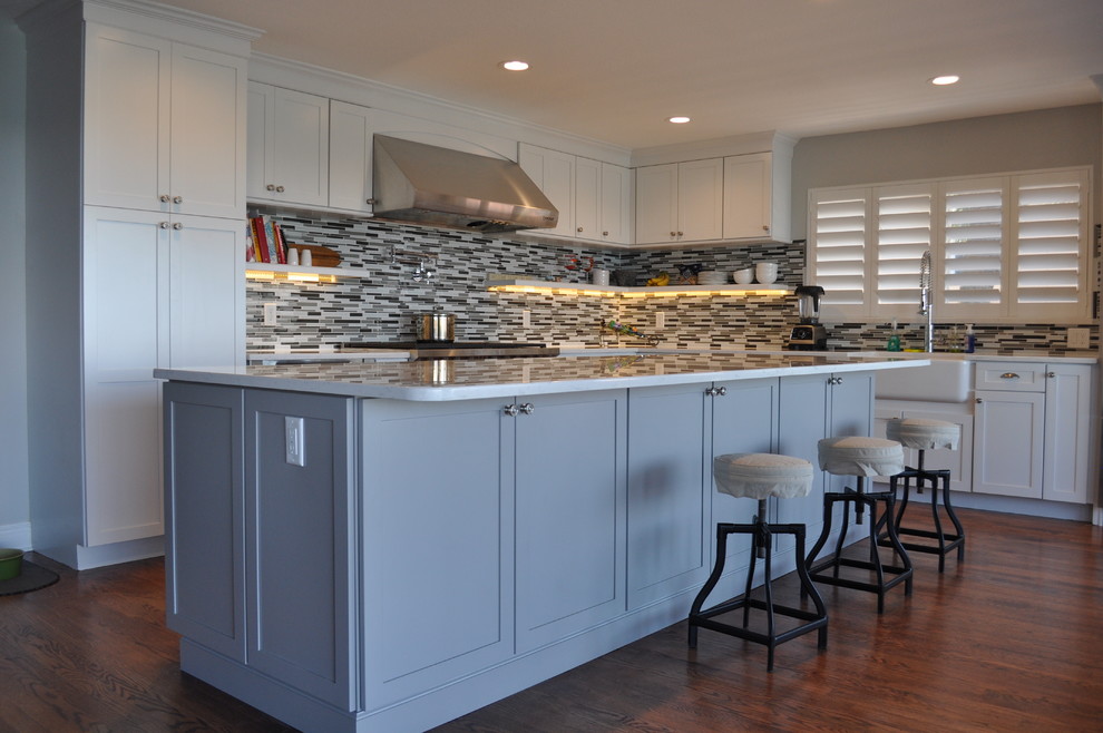 Mid-sized beach style kitchen in Tampa with recessed-panel cabinets, blue cabinets, multi-coloured splashback, stainless steel appliances and medium hardwood floors.