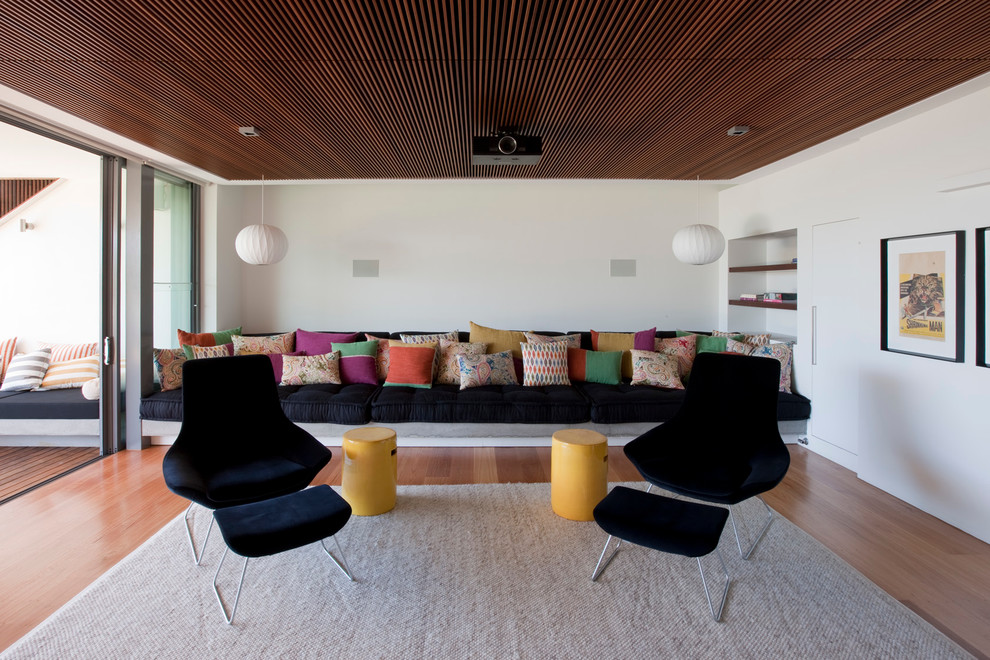 This is an example of a contemporary family room in Sydney with white walls, light hardwood floors and no fireplace.