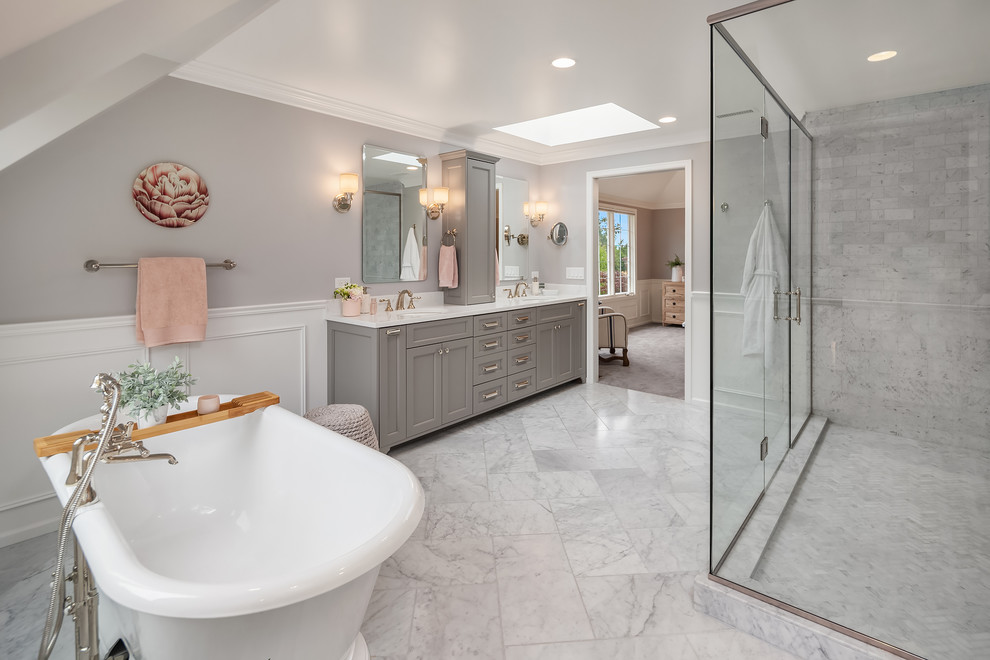 Expansive traditional master bathroom in Seattle with grey cabinets, a freestanding tub, gray tile, marble, grey walls, marble floors, an undermount sink, engineered quartz benchtops, grey floor, a hinged shower door, recessed-panel cabinets, a corner shower and white benchtops.